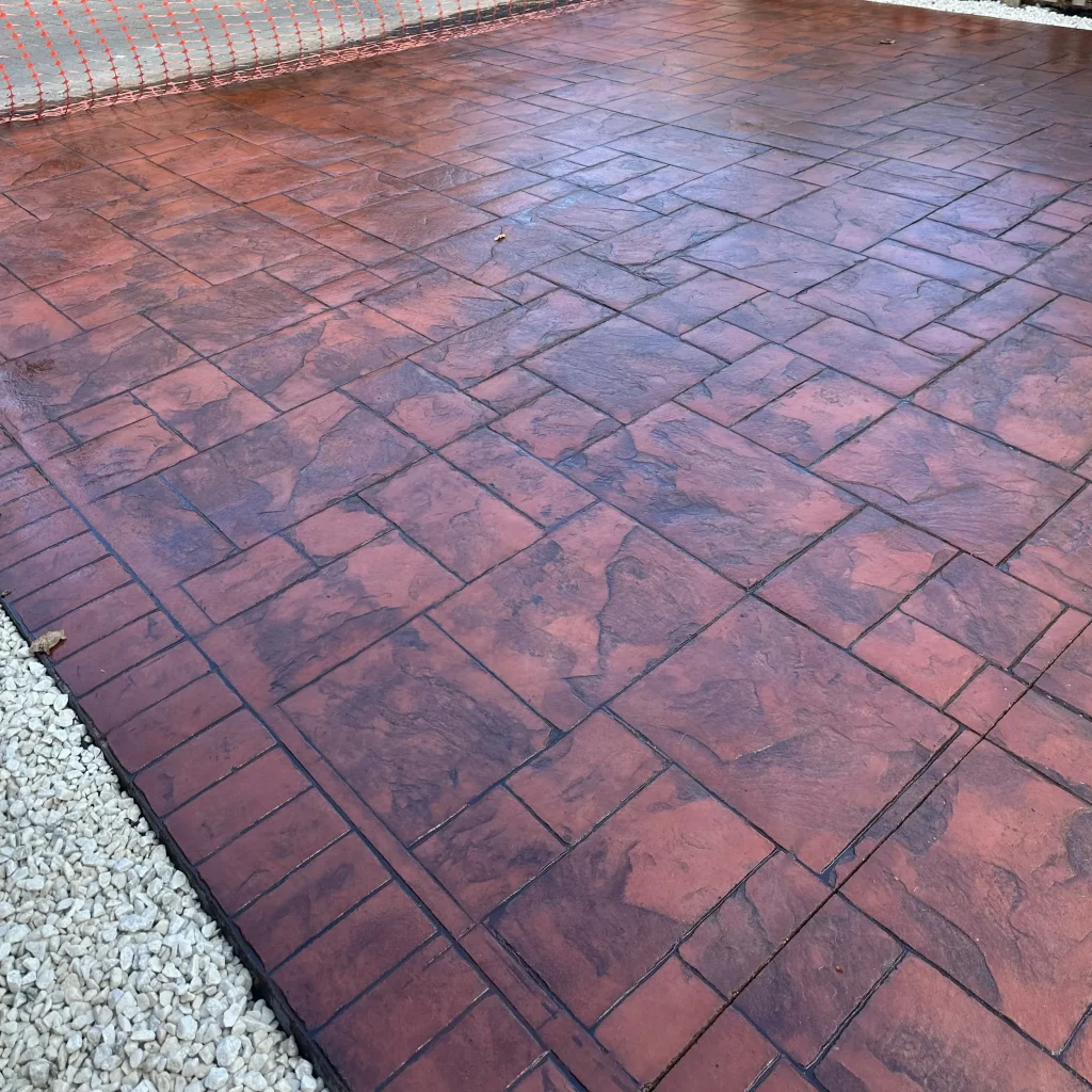 red-stamped-concrete-driveway-white-gravel